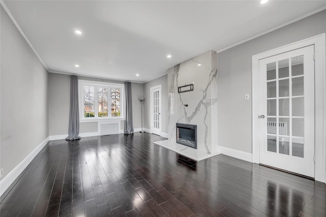 unfurnished living room with dark wood-type flooring, crown molding, and a premium fireplace