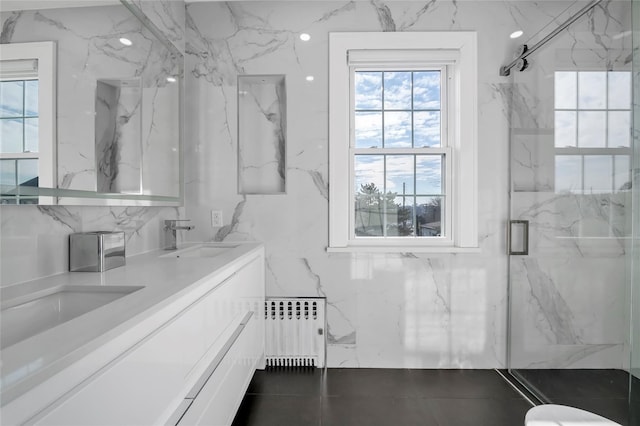 bathroom with a shower with shower door, radiator, and vanity