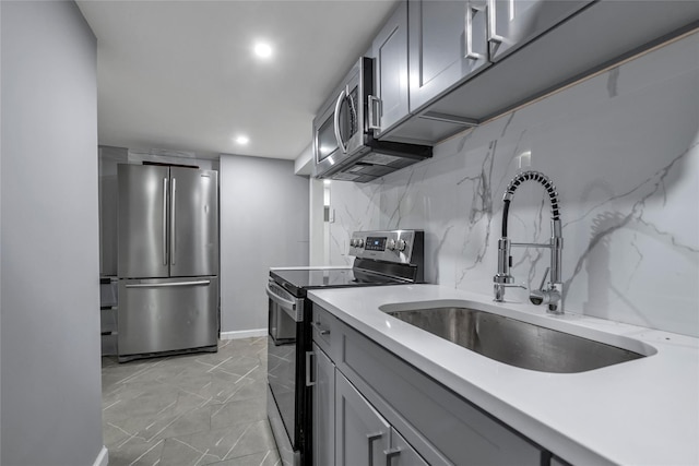 kitchen featuring decorative backsplash, sink, gray cabinets, and stainless steel appliances