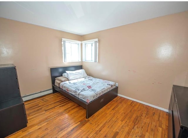 bedroom with wood-type flooring and a baseboard radiator