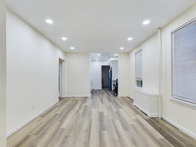 empty room with baseboards, light wood finished floors, and recessed lighting