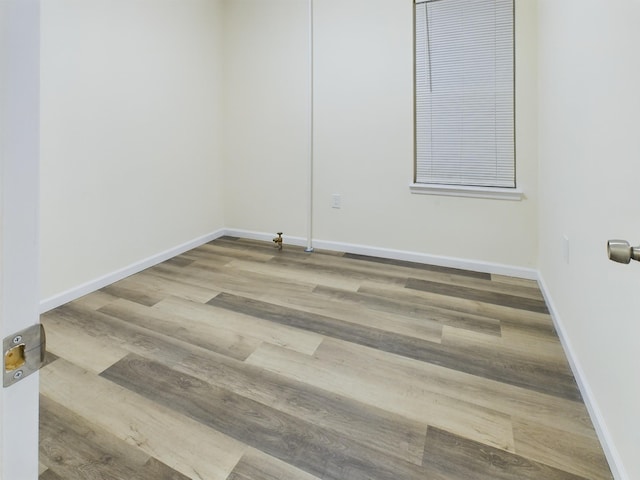 empty room featuring baseboards and wood finished floors