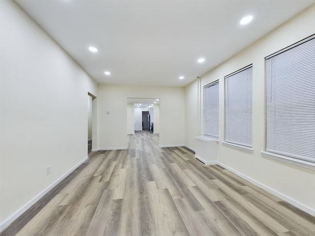 unfurnished room with baseboards, recessed lighting, and light wood-style floors