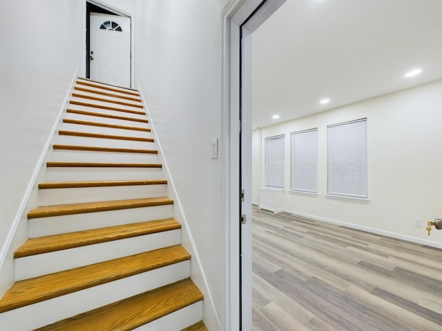 stairway featuring recessed lighting, baseboards, and wood finished floors