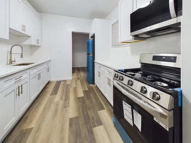 kitchen with white cabinets, appliances with stainless steel finishes, and light countertops