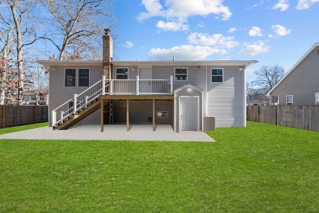 back of property featuring a lawn, a deck, and a patio area