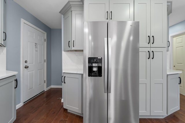 kitchen featuring stainless steel refrigerator with ice dispenser, dark wood-type flooring, and backsplash