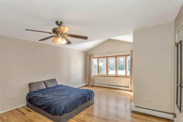 bedroom with a baseboard radiator, vaulted ceiling, ceiling fan, and light hardwood / wood-style floors