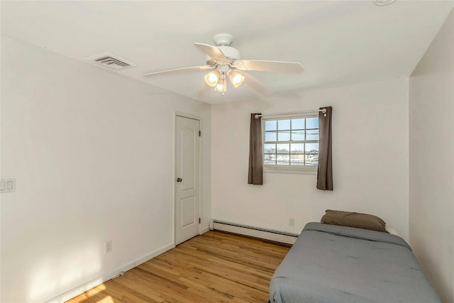 bedroom featuring ceiling fan, baseboard heating, and light hardwood / wood-style flooring