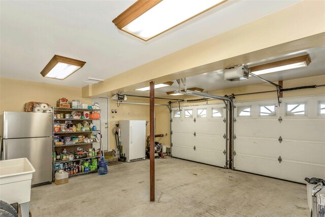 garage featuring a garage door opener, stainless steel fridge, and white fridge