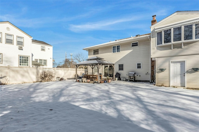 snow covered back of property with a gazebo