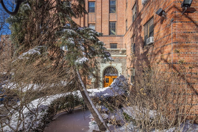 snow covered building with cooling unit