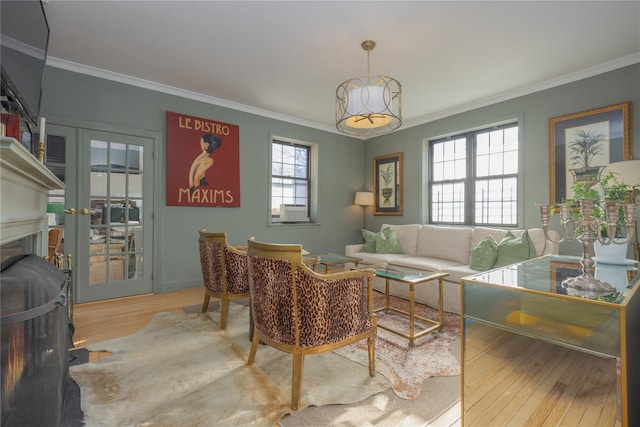 living room with french doors, ornamental molding, light hardwood / wood-style flooring, and cooling unit