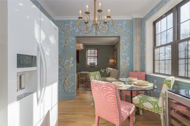 dining room featuring crown molding, an inviting chandelier, and light hardwood / wood-style floors