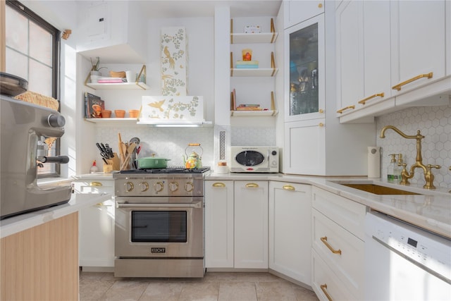 kitchen with sink, light stone counters, backsplash, white appliances, and white cabinets