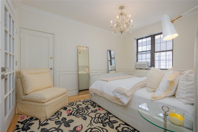 bedroom with crown molding, a chandelier, and light hardwood / wood-style flooring