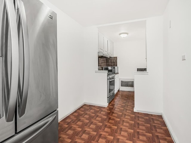 kitchen featuring dark parquet floors, stainless steel appliances, and white cabinetry