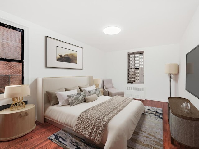 bedroom with hardwood / wood-style floors and radiator heating unit