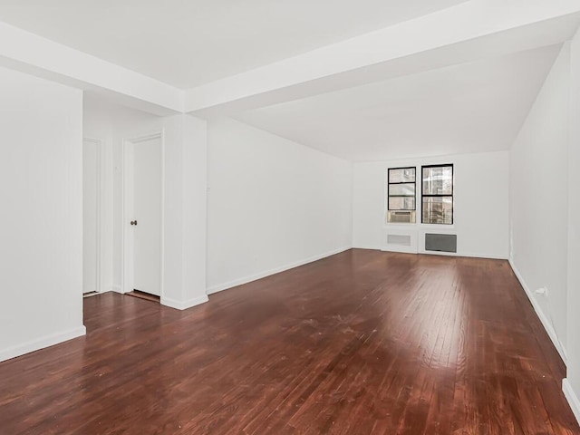 empty room with built in features and dark hardwood / wood-style floors