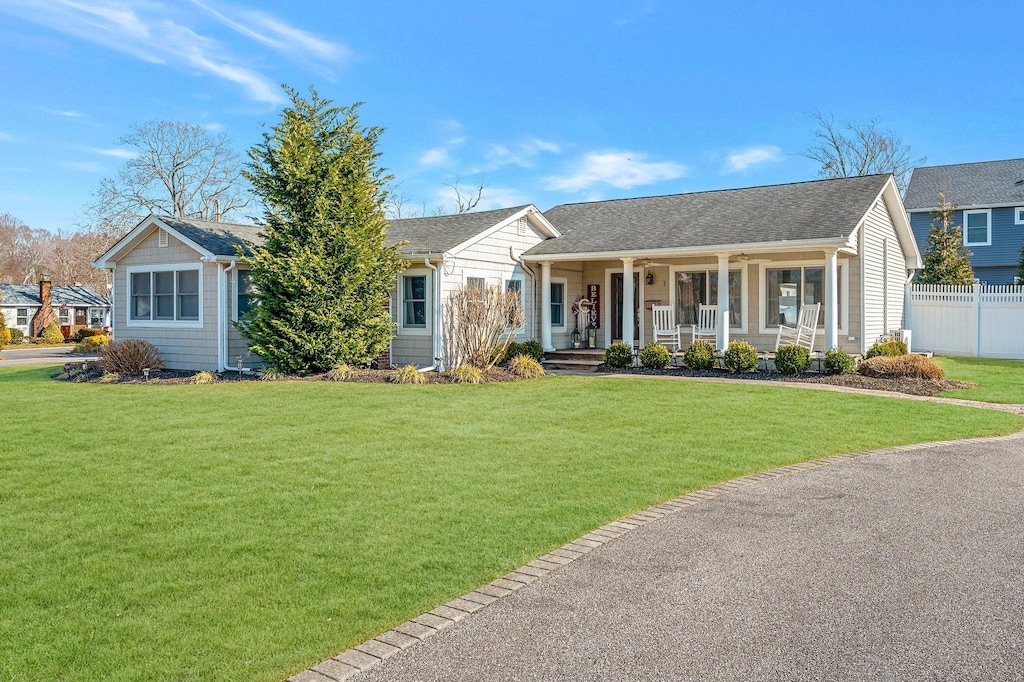 ranch-style home with covered porch and a front yard