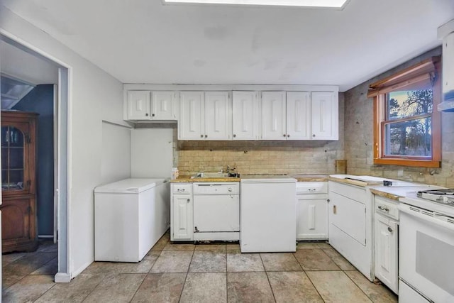 kitchen with sink, white cabinets, decorative backsplash, fridge, and white range