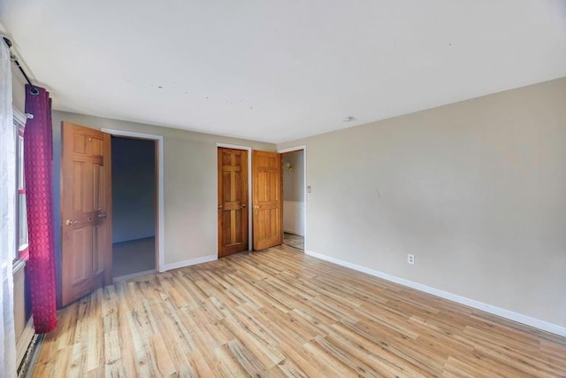 unfurnished bedroom featuring light hardwood / wood-style floors and a closet