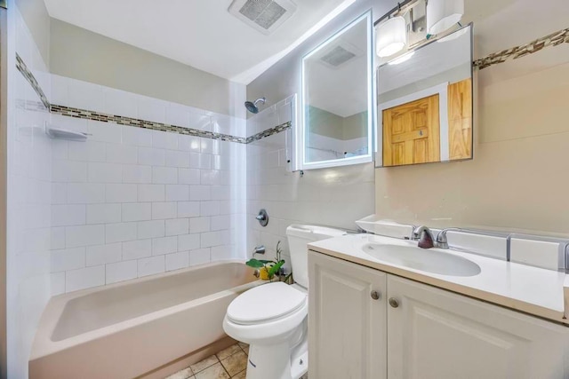 full bathroom featuring tiled shower / bath combo, vanity, tile patterned flooring, and toilet