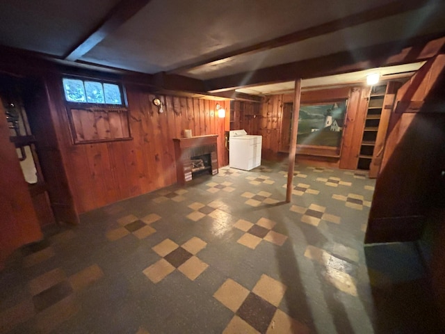 basement featuring a fireplace, wooden walls, and washer / dryer