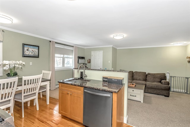 kitchen featuring dishwasher, dark stone counters, an island with sink, sink, and crown molding