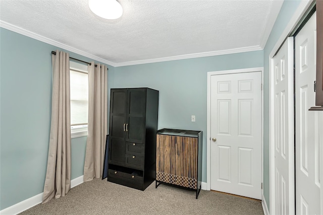 bedroom featuring light carpet, ornamental molding, and a textured ceiling