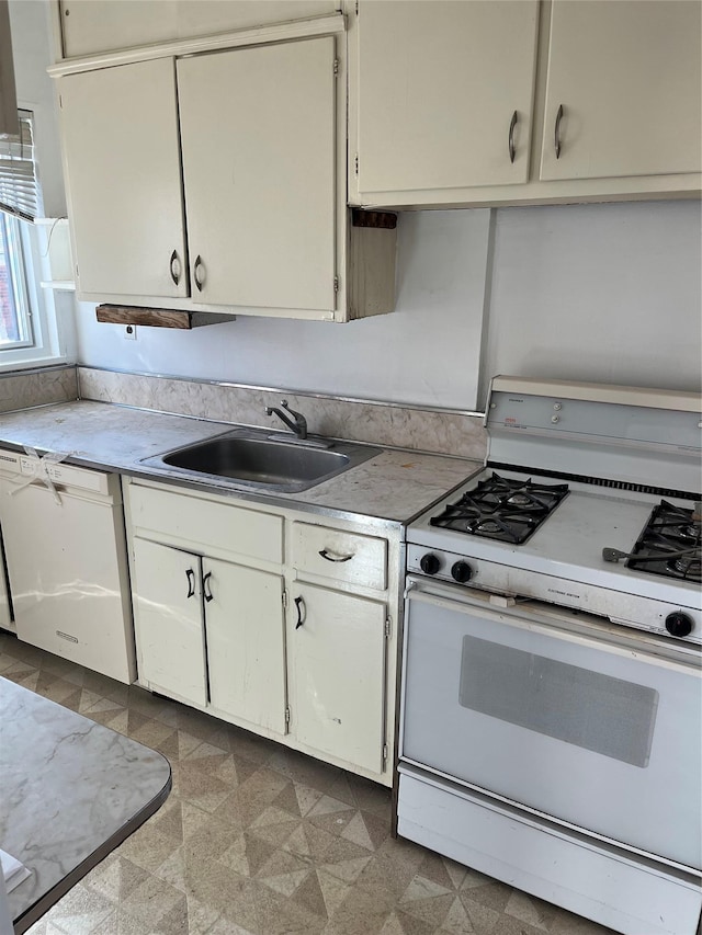 kitchen with white cabinetry, white appliances, and sink