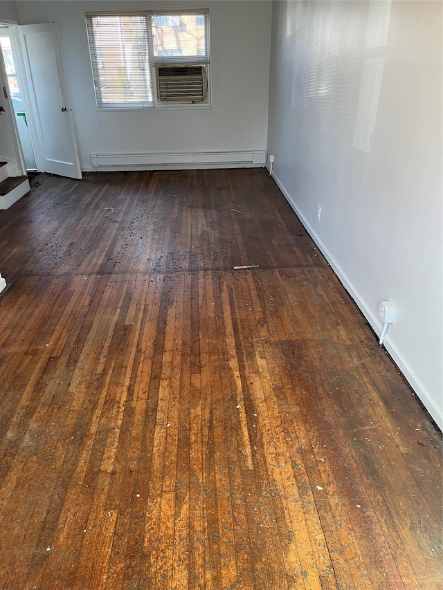 unfurnished room featuring cooling unit, a baseboard heating unit, and dark hardwood / wood-style floors