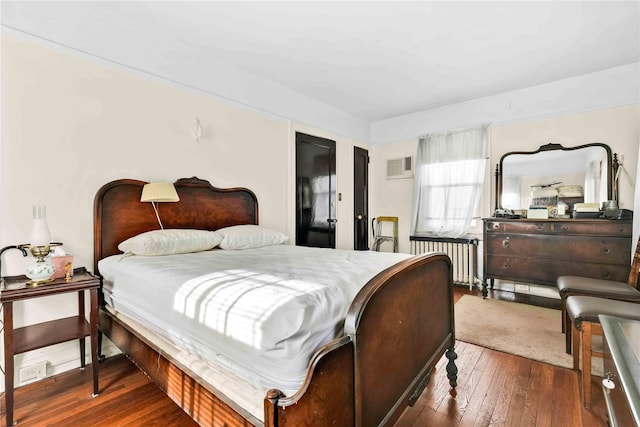 bedroom featuring radiator and dark hardwood / wood-style flooring