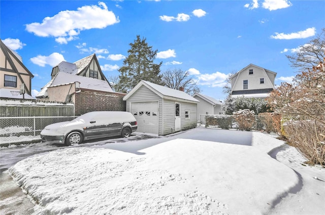 yard layered in snow with an outdoor structure and a garage