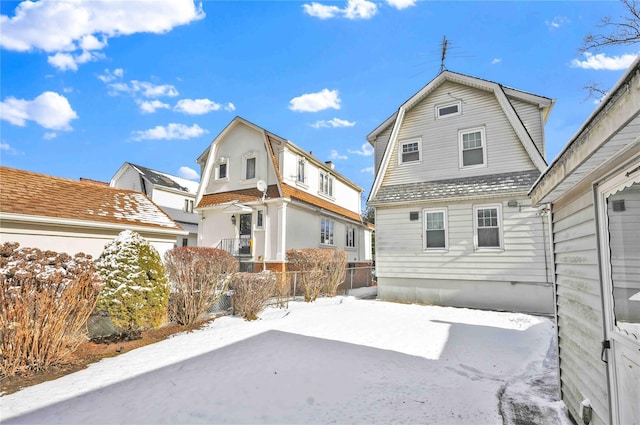 view of snow covered back of property