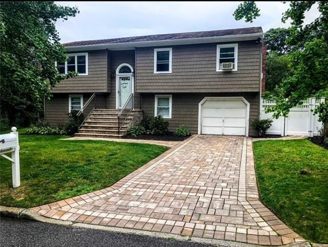 split foyer home featuring a front yard and a garage