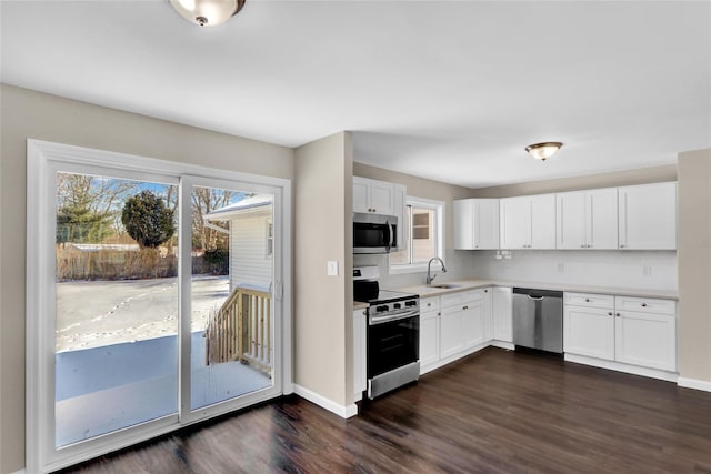 kitchen featuring tasteful backsplash, white cabinetry, sink, dark hardwood / wood-style flooring, and stainless steel appliances