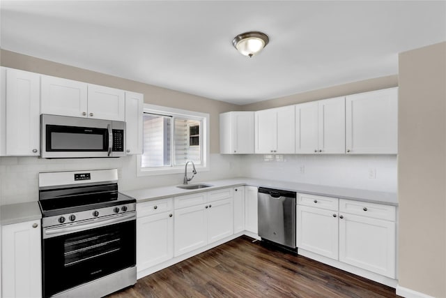 kitchen featuring sink, white cabinets, backsplash, stainless steel appliances, and dark wood-type flooring