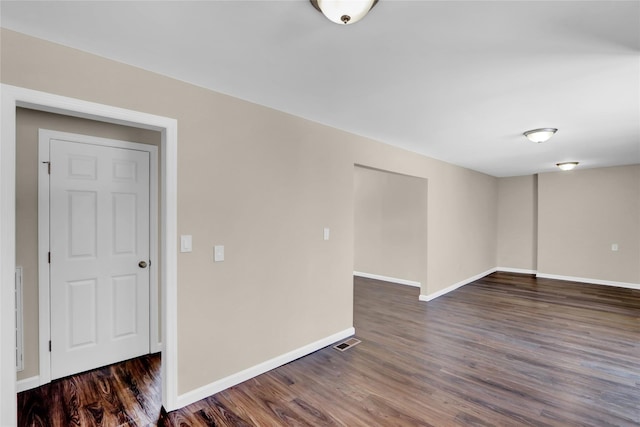 unfurnished room with dark wood-type flooring