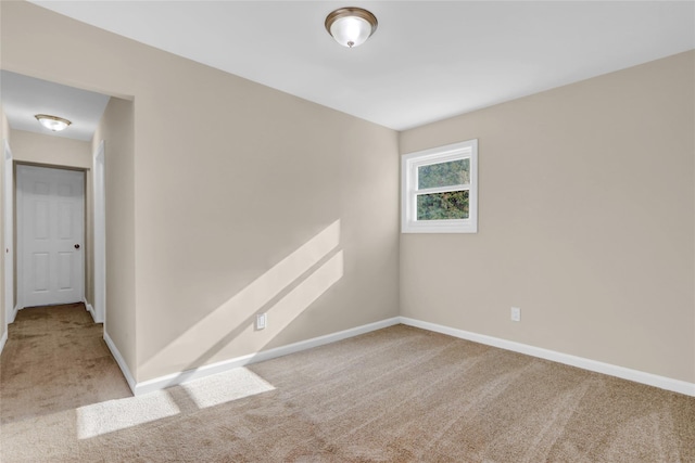 unfurnished room featuring light carpet