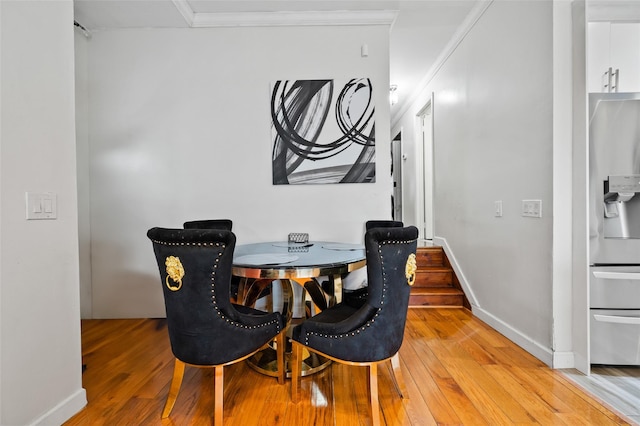 dining room with hardwood / wood-style floors and crown molding