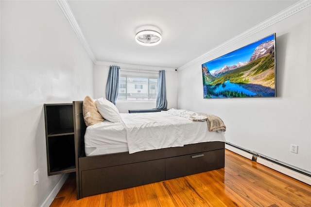 bedroom featuring hardwood / wood-style flooring, a baseboard radiator, and ornamental molding