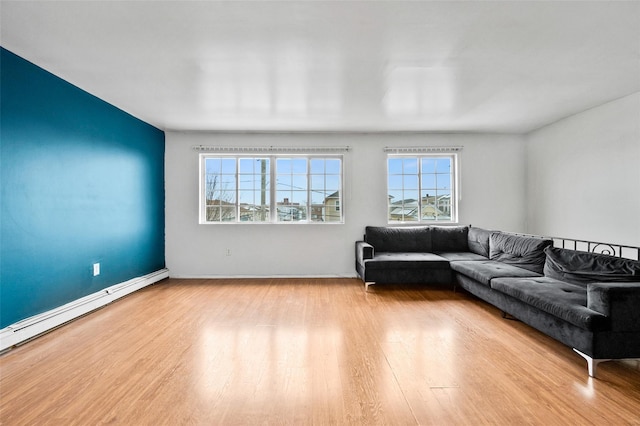 living room featuring a baseboard heating unit and light hardwood / wood-style flooring