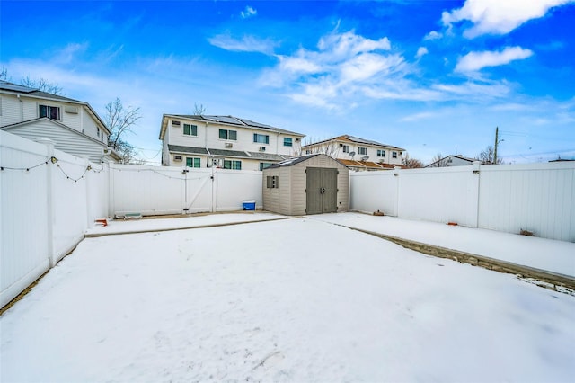 yard covered in snow featuring a storage unit