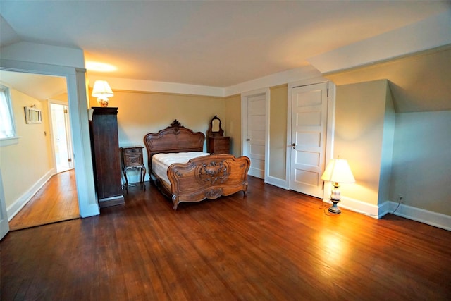 bedroom featuring dark wood-type flooring and lofted ceiling