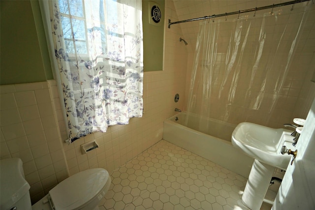 bathroom featuring tile patterned floors, toilet, tile walls, and shower / bathtub combination with curtain