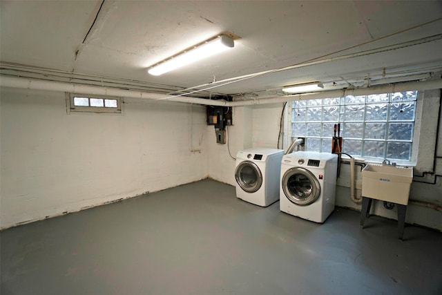 clothes washing area with sink, washer and dryer, and a wealth of natural light