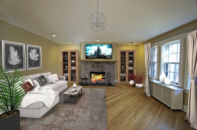 living room featuring a fireplace, radiator heating unit, hardwood / wood-style flooring, and a notable chandelier