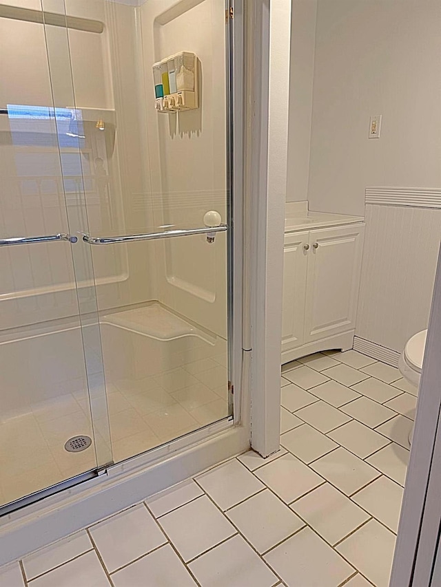 bathroom with tile patterned flooring, toilet, and walk in shower