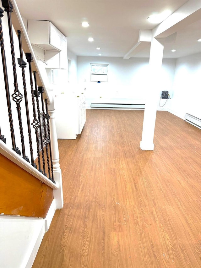 basement with a baseboard radiator and light wood-type flooring